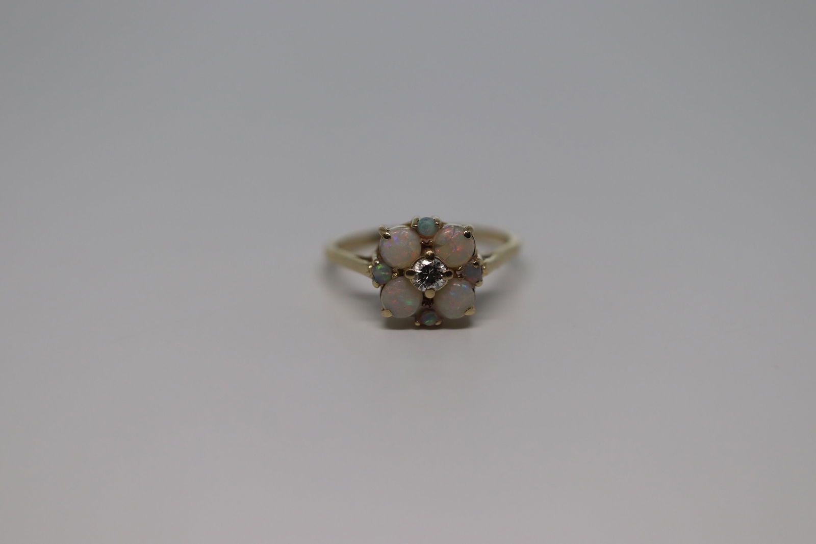 14Kt Art Deco Opal & Diamond Ring: A ladies Art Deco 14Kt Yellow Gold diamond ring with Round Opal Stones. The diamond weighs approx 0.25ct and there are a total 8 Opal stones set around the center stone. The ring weight is 3.70gr.