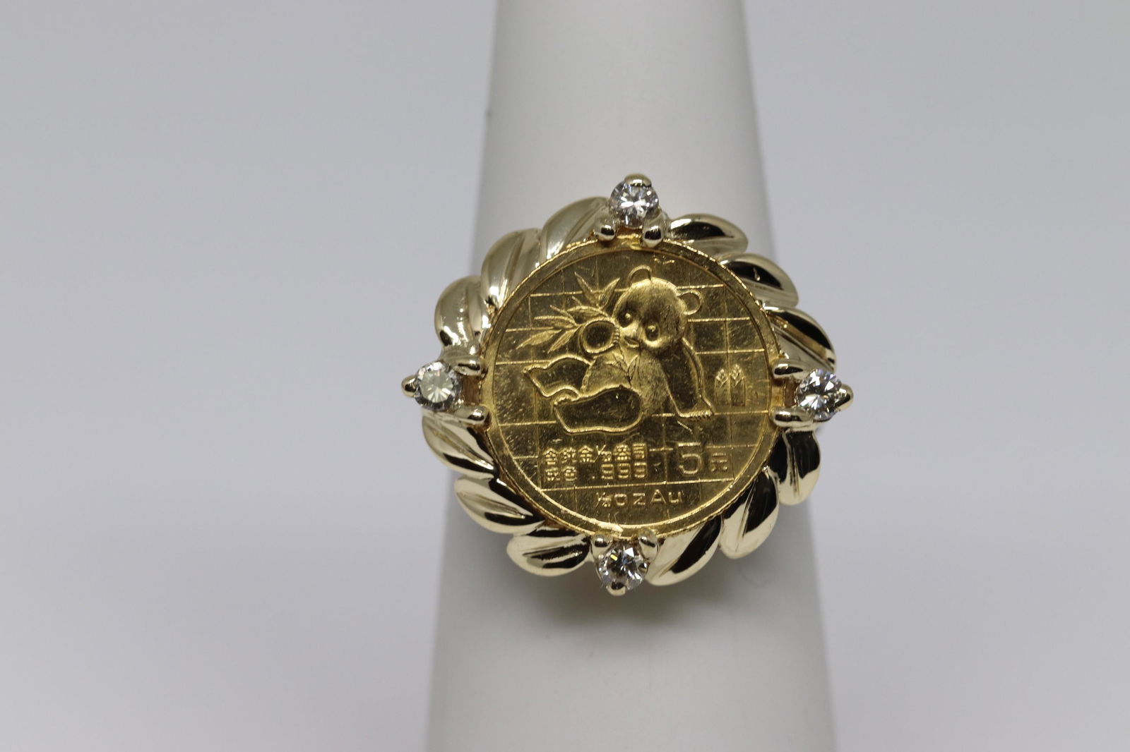 Panda Coin(24k)Ring: Unique 24k Panda coin ring. The coin is set in the center. There are a total of 4 round diamonds set around the coin. The diamonds are VS1-VS2 clarity. The ring is 14 karat yellow gold and weights in