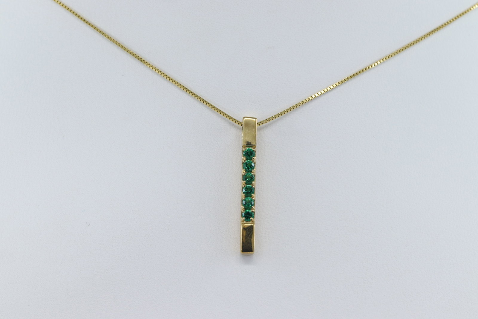 Ladies Yellow Gold W/ Emerald Stones: A ladies 10kt Yellow Gold Emerald Necklace. The necklace has a total of 6 round Emerald stone set on bar pendant. Legnth 20.00".