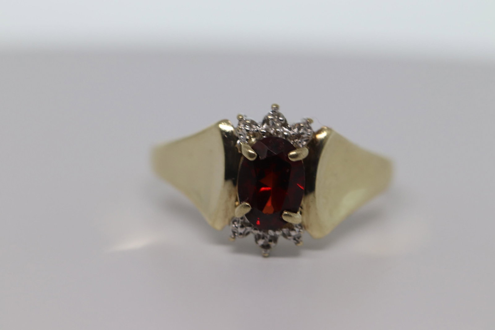 Ladies Diamond & Garnet Ring: A ladies 10kt Yellow Gold Diamond and Garnet ring. The ring has a total of 2 round brilliant diamonds and an oval shapped garnet stone in the center. The ring size is 6.50. SKU02QMSIDC1