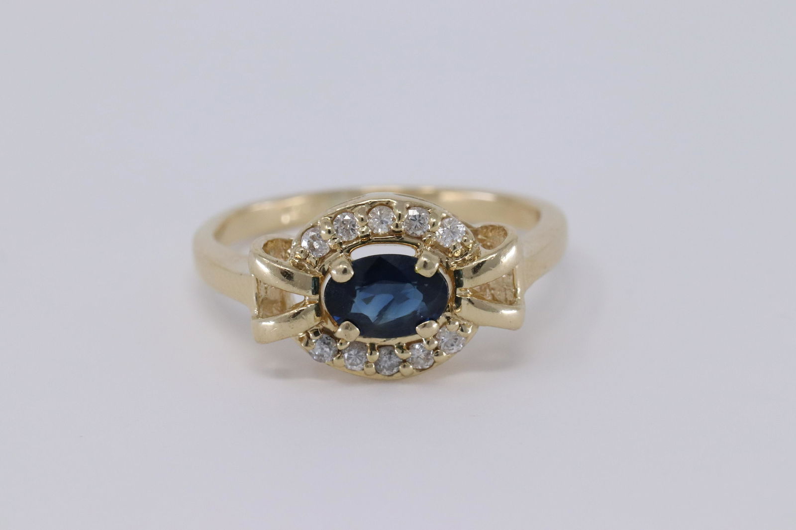 14Kt Diamond w/ Blue Sapphire Ladies Ring: A ladies 14kt Yellow Gold Diamond ring. The ring has a gorgeous Blue Sapphire Stone in the center. There are a total of 10 round brilliant diamonds set around the center stone. Diamonds weight 2.60 gr
