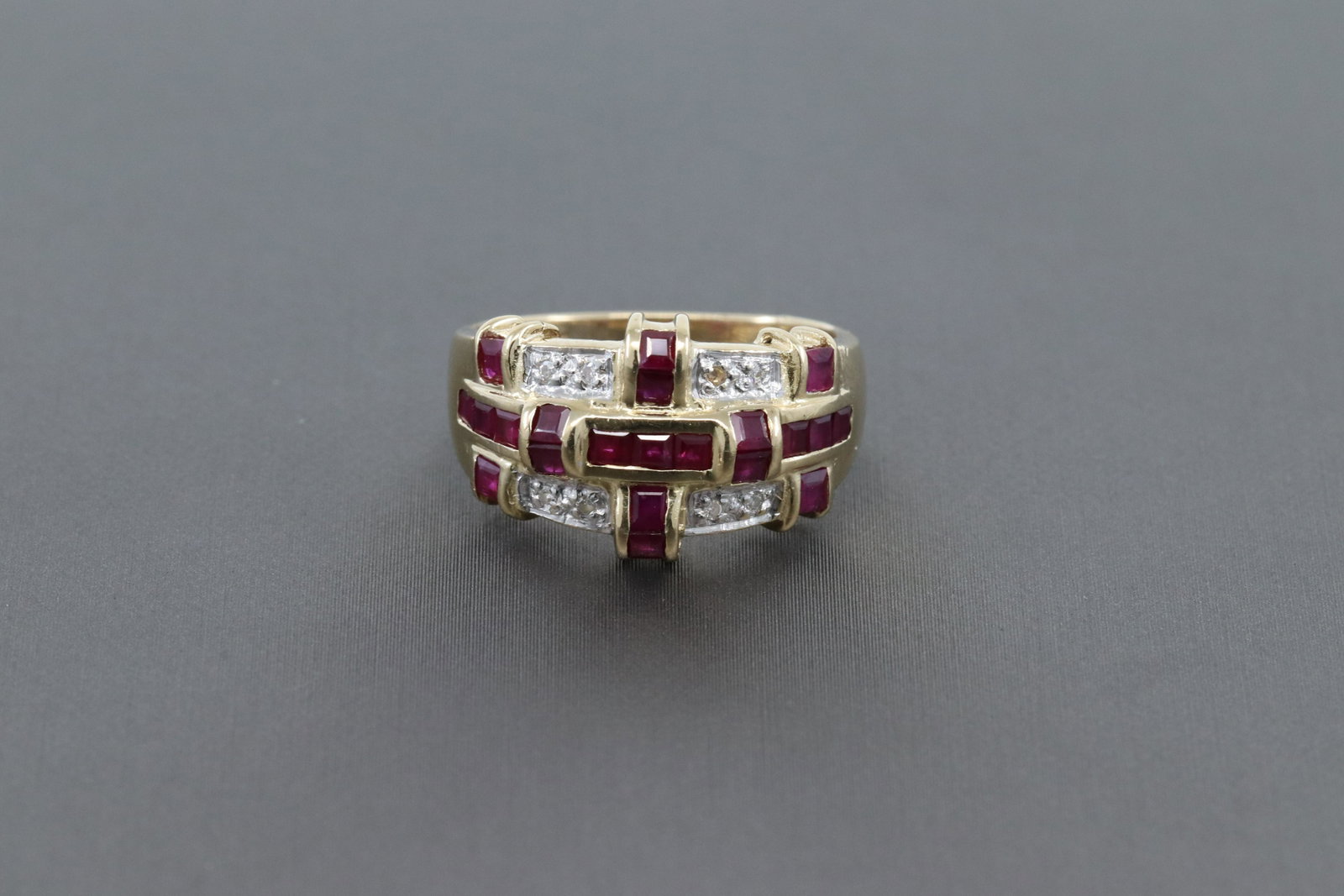 14k Gold Ladies Diamond and Ruby Ring: A ladies Ring 14K Gold Yellow Diamond w/ Ruby's ring. The ring weights 4.8 grams. Total diamond weight is approx 0.08 tcw. There are a total of 22 Princess Cut Ruby's. The ring size is: 6.50.