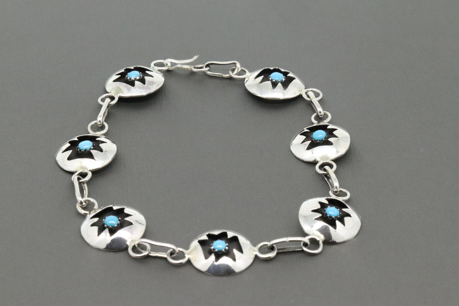 Navajo Sterling silver link bracelet.: Sterling silver link bracelet with 7 round shadowbox links that have a 4mm turquoise stone in each link. It measures approximately 8" long by 9/16 wide. Handcrafted by Navajo artisan David L. Morgan. 
