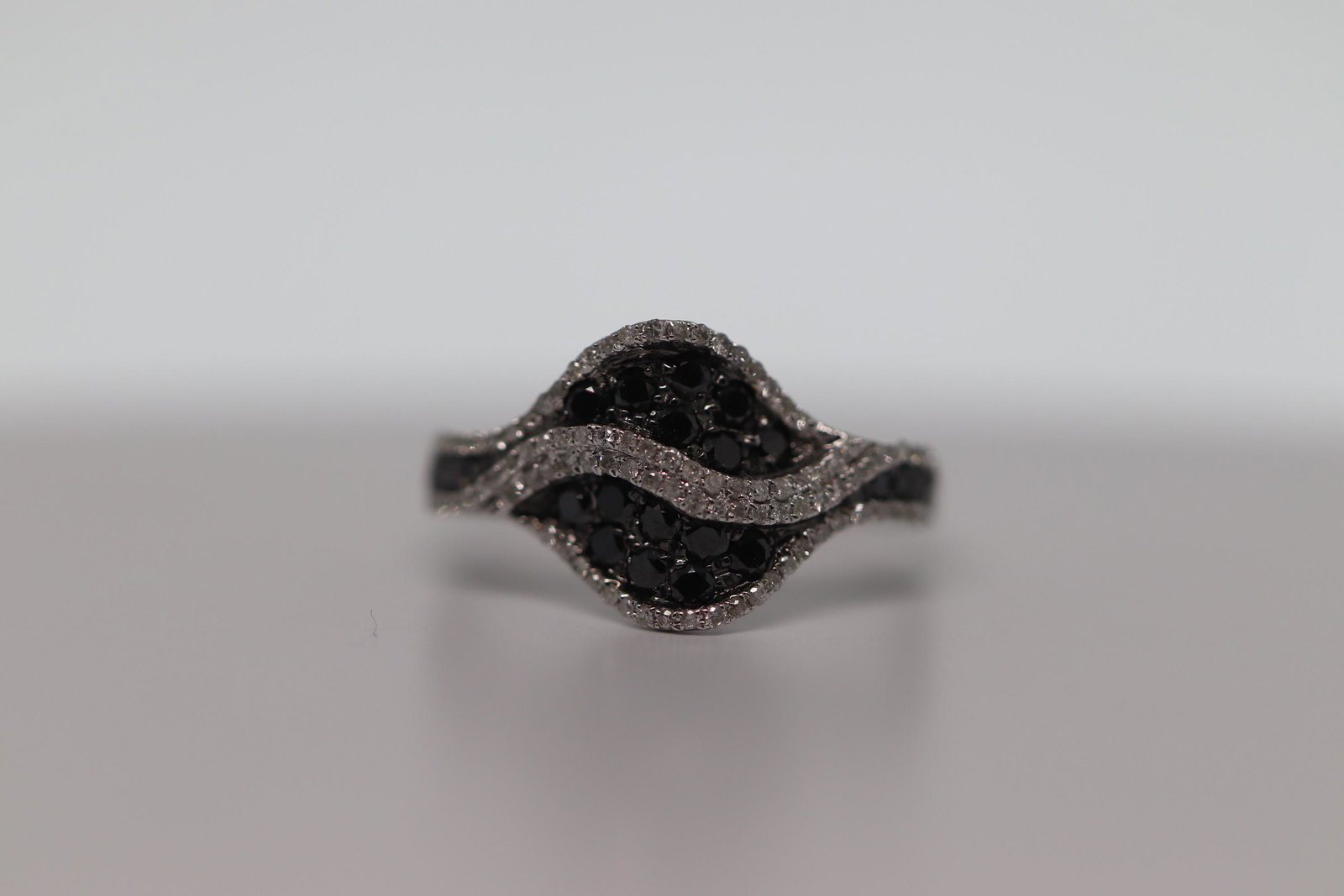 14Kt Modern Ladies Diamond Ring: A ladies Modern 14kt White Gold White and Black Diamond ring. The ring has diamonds total weight is 0.75cttw. The ring size 7.00. The diamonds in sharred prong setting. Ring is in mint condition, grea