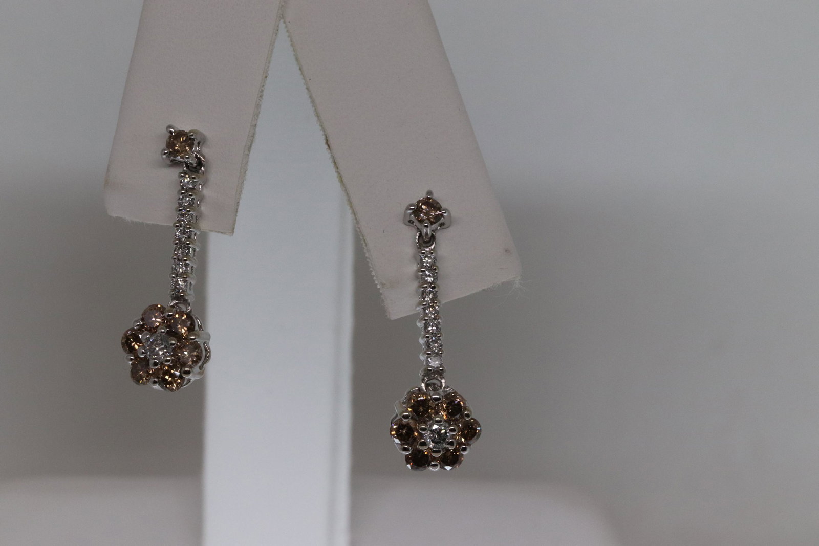 18kt Diamond Earrings: A Unique and gorgeous 18kt white gold diamond earrings. The earrrings has 2 colored diamonds Brown and white natural diamonds. There are total of 30 round brilliant diamonds. The length is about 1.00i