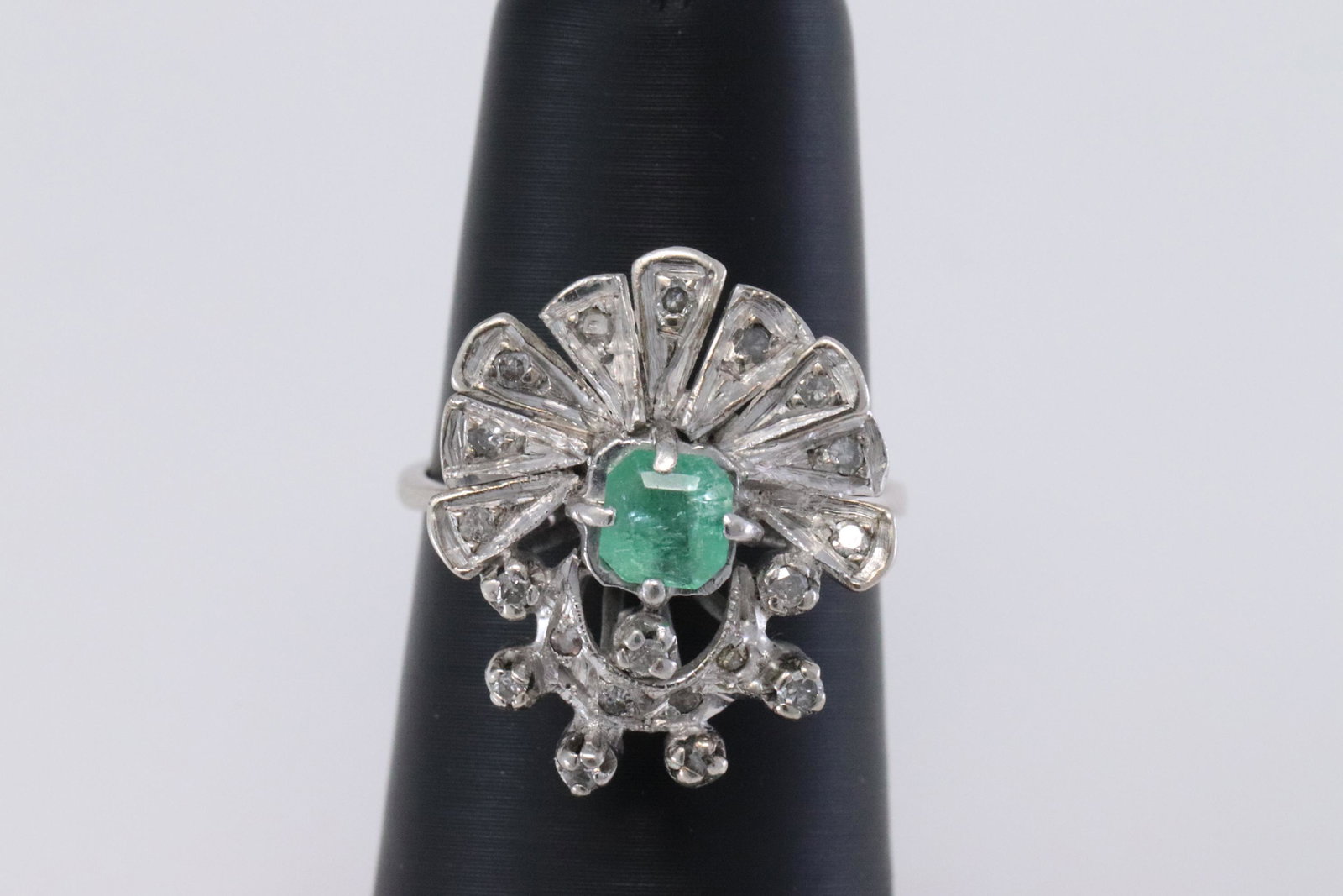 Art Deco Diamond & Emerald Ring: A ladies White Palladium Diamond ring with an Emerald stone in the center. There are a total of 20 round diamonds. Ring size: 6.50. Total weight of this Art Deco Palladium Diamond Ring 4.00 grams.