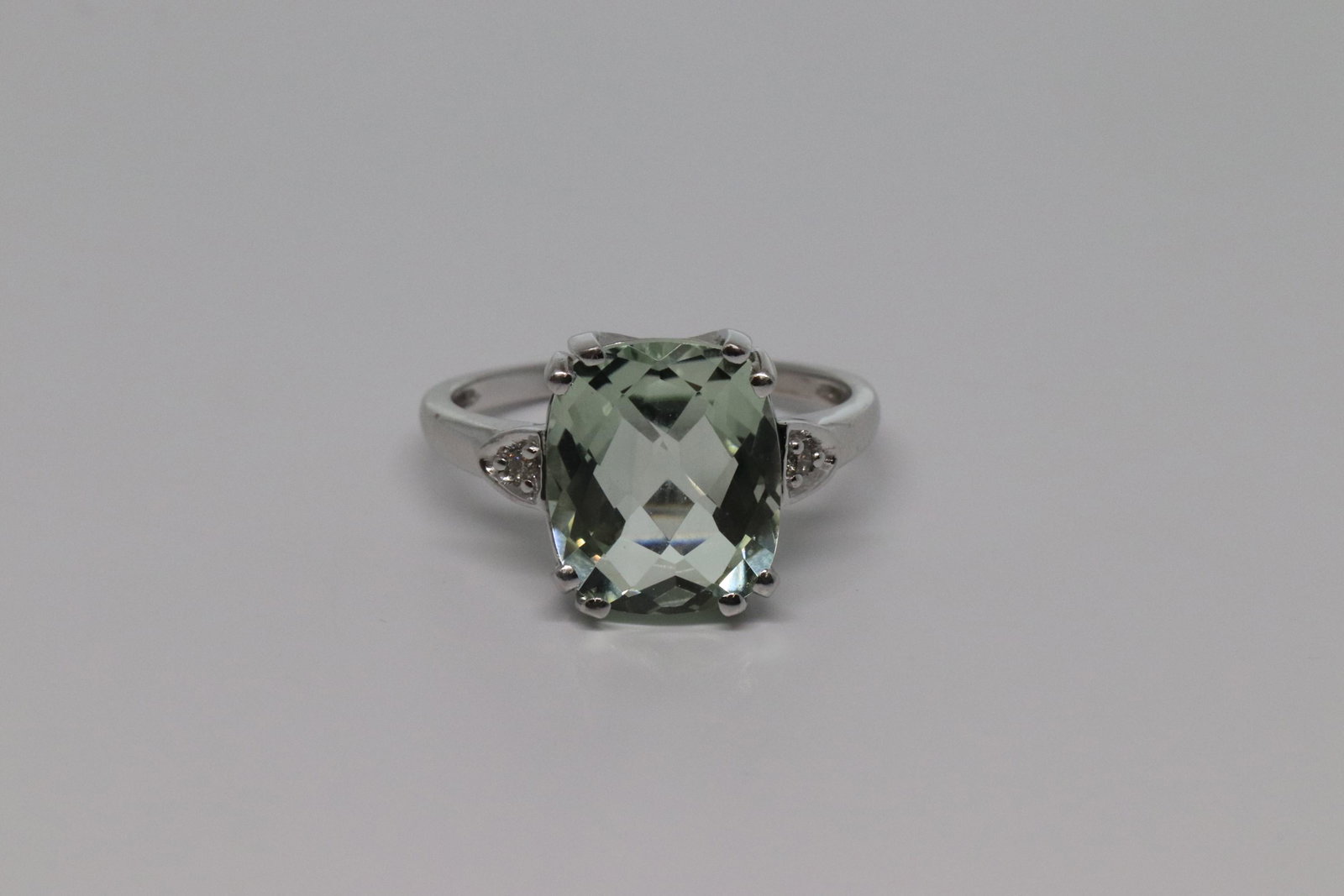 Ladies Diamond Ring: A beautiful 10kt White Gold Diamond ring. The ring has 2 round brilliant diamonds. The center stone has aquamarine colored stone in the center. The ring size is 6.50. SKU03MDJF2