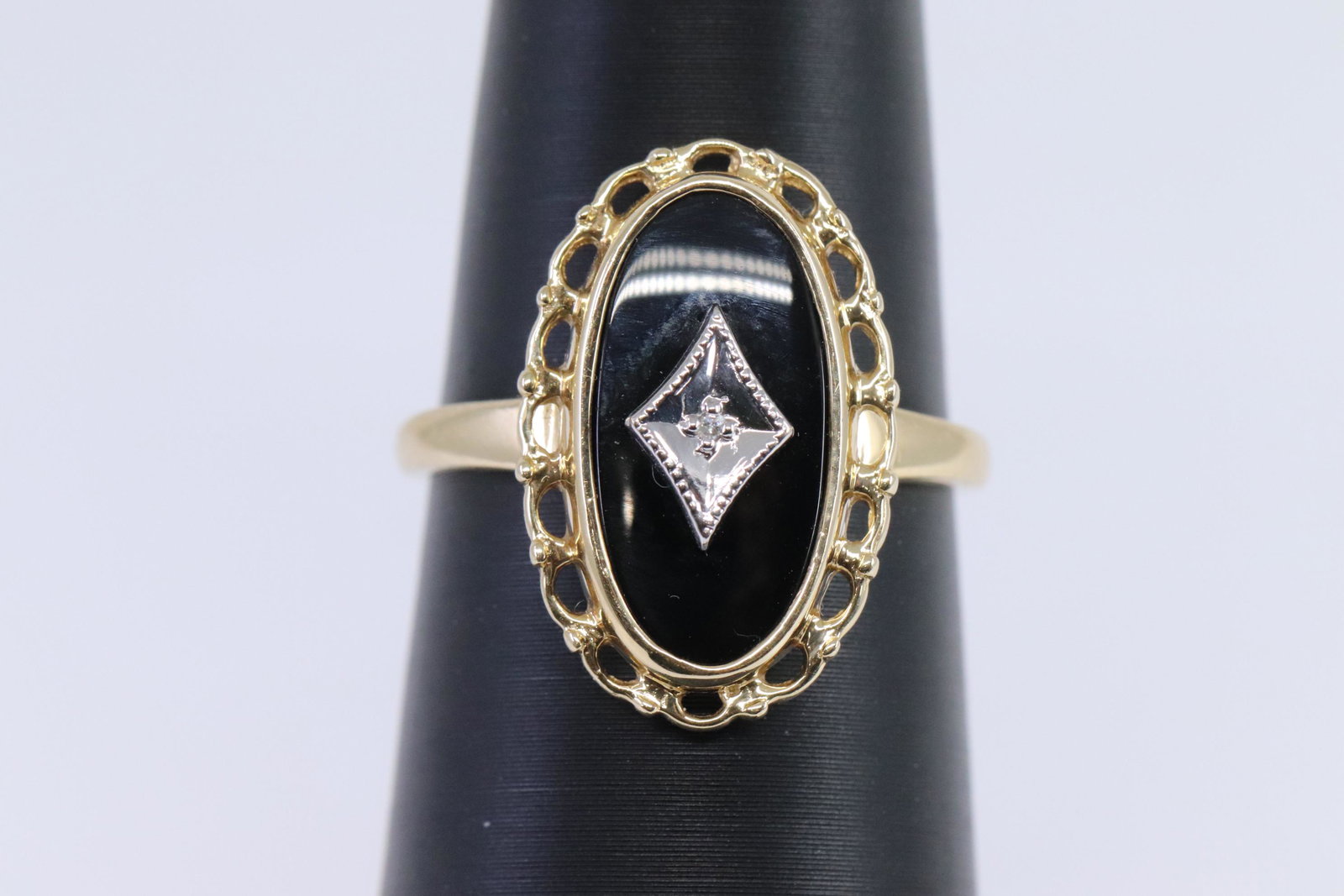 Ladies Art Deco Diamond Ring: A ladies Yellow Gold Art Deco ring design. Ring has a Black Onyx stone in the center and a round diamond stone in the center. Ring size: 6.75. Ring weight: 3.50 grams.