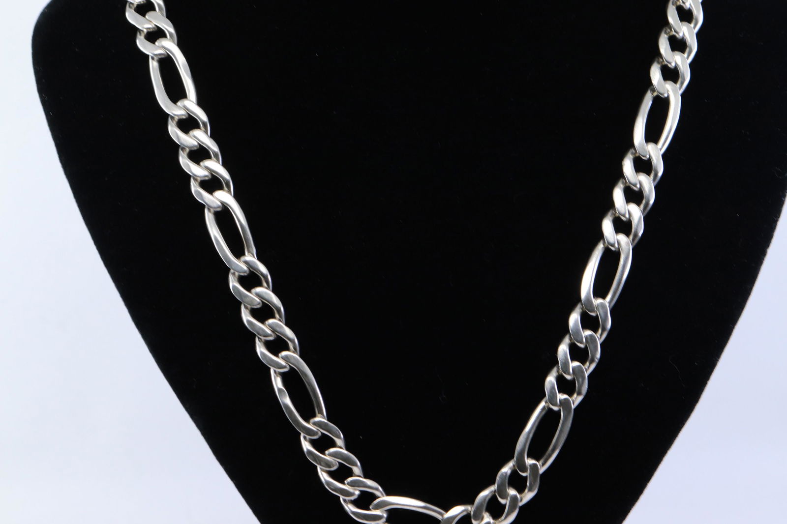 .925 Men's Silver Figaro Chain: A Men's Silver .925 Figaro chain. Chain length: 23.00". Total weight: 102.40 grams. A part by the clasp is broken but still can be worn.