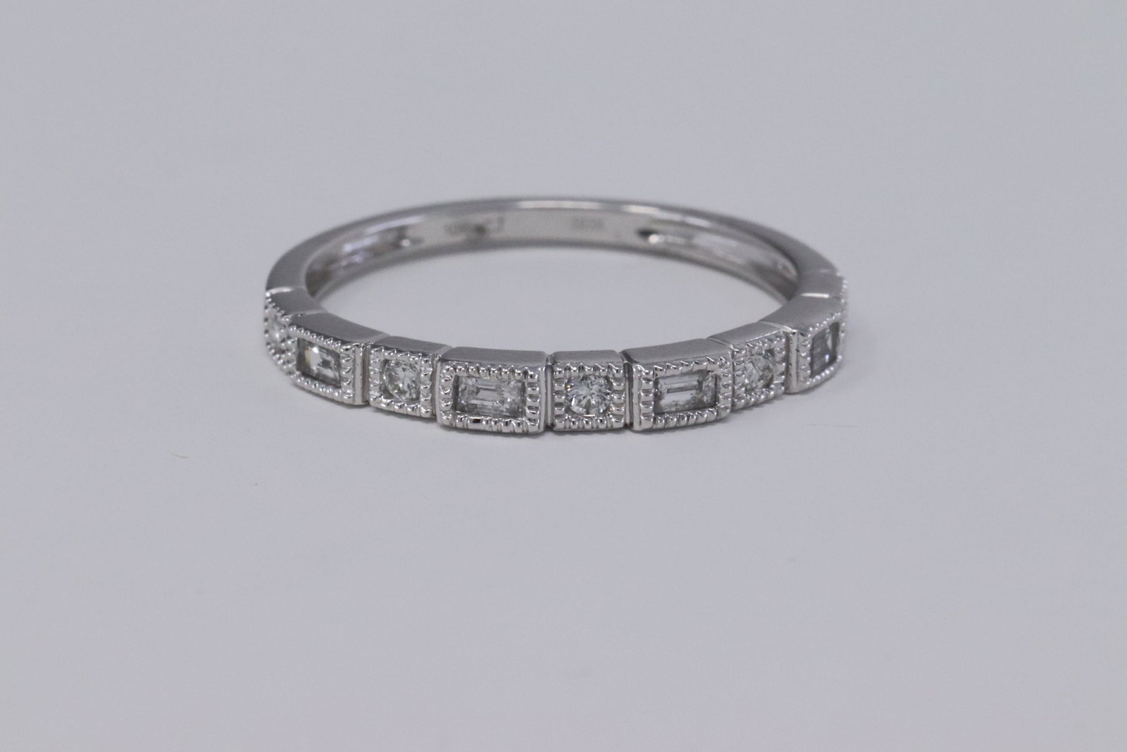 Bezel Set Baguette & Round Diamond Milgrain Stackable: Bezel Set Baguette & Round Diamond Milgrain Stackable Band Ring. Stone:DiamondShape:roundColor:I-JClarity:I2-I3Total Diamond Weight:0.13 caratsSetting Type:Bezel. Ring Size:7Gender:WomensResizable:Yes