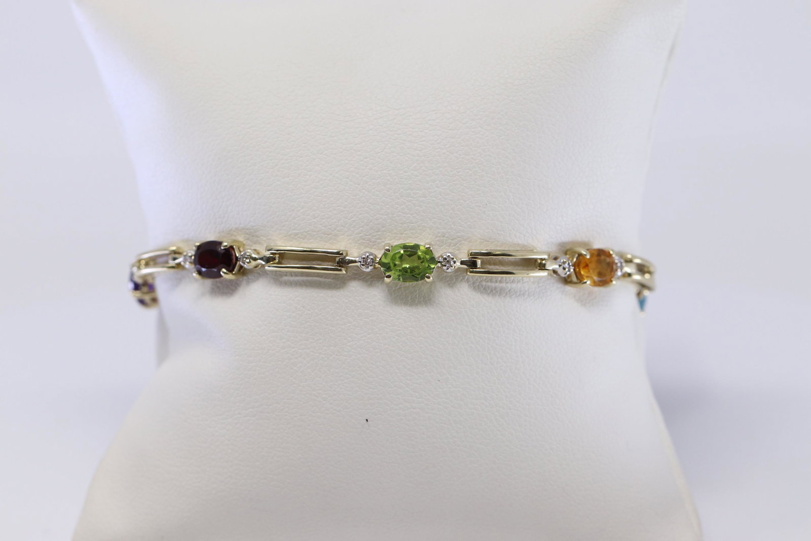 Diamond | Multicolor Gemstone Yellow Gold Bracelet: A ladies Yellow Gold Diamond bracelet. Bracelet has multi colored stone set on the bracelet such as: Aquamarine, Amethsyt, Garnet, Peridote and Citrine. There are a total of 14 round brilliant diamond