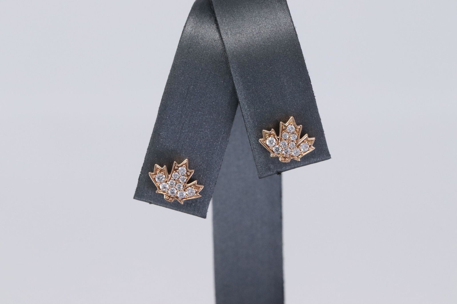 14KT Rose Gold Maple Leaf Diamond Stud Earrings: A ladies 14kt Rose Gold Diamond stud earrings. These stud earrings are Maple Leaf Design. There are a total of 20 round brilliant diamonds. Diamonds are VS-SI clarity. Diamonds weight 0.20cttw. Mint C