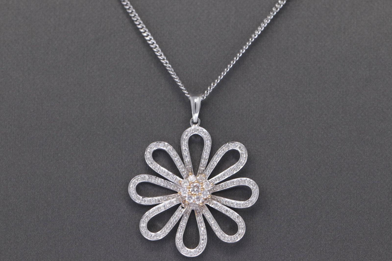18k DAISY Diamond Pendant w/ Necklace: A ladies Beautiful and Unique Modern Daisy Design Diamond Pendant. The pendant and necklace are both 18k White gold. The diamond weight approx 0.75-1.00tcw. The diamonds are VS1-VS2 clarity, E-F color