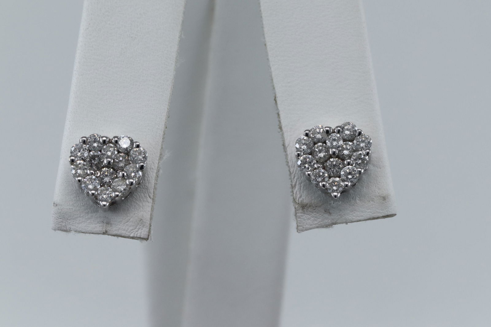 18Kt Cluster Heart Diamond Earrings: A gorgeous 18kt White Gold Cluster diamond stud earrings. The earrings are heart shape design with a total of 28 round brilliant diamonds. The diamonds weigh approx 1.00cttw. Backings are also 18kt. S