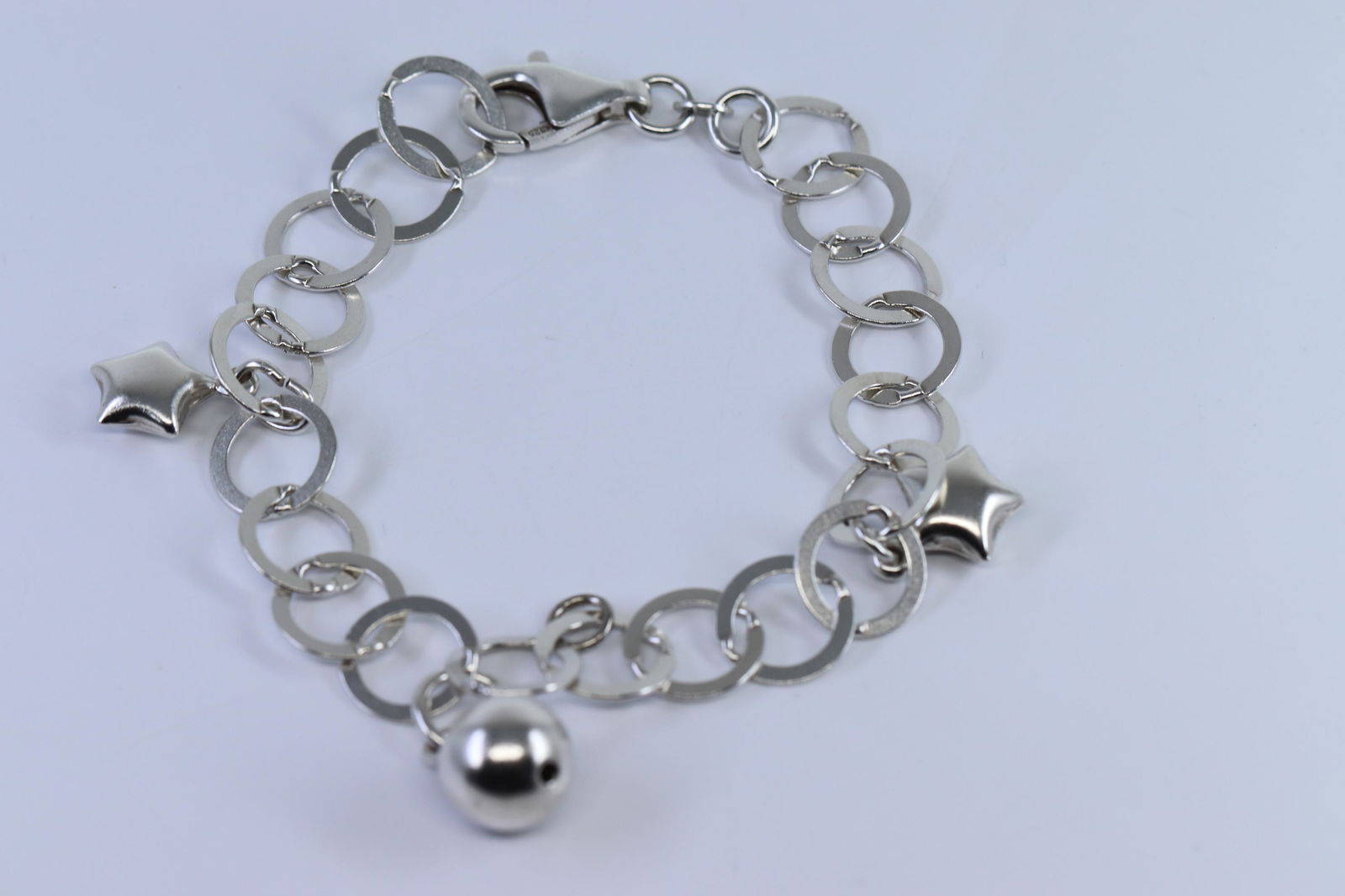 Sterling Silver Ladies Bracelet: A ladies .925 sterling silver bracelet. Bracelet also has 2 star charms and ball charm. Length 7.50. Total weight 9.80 grams.