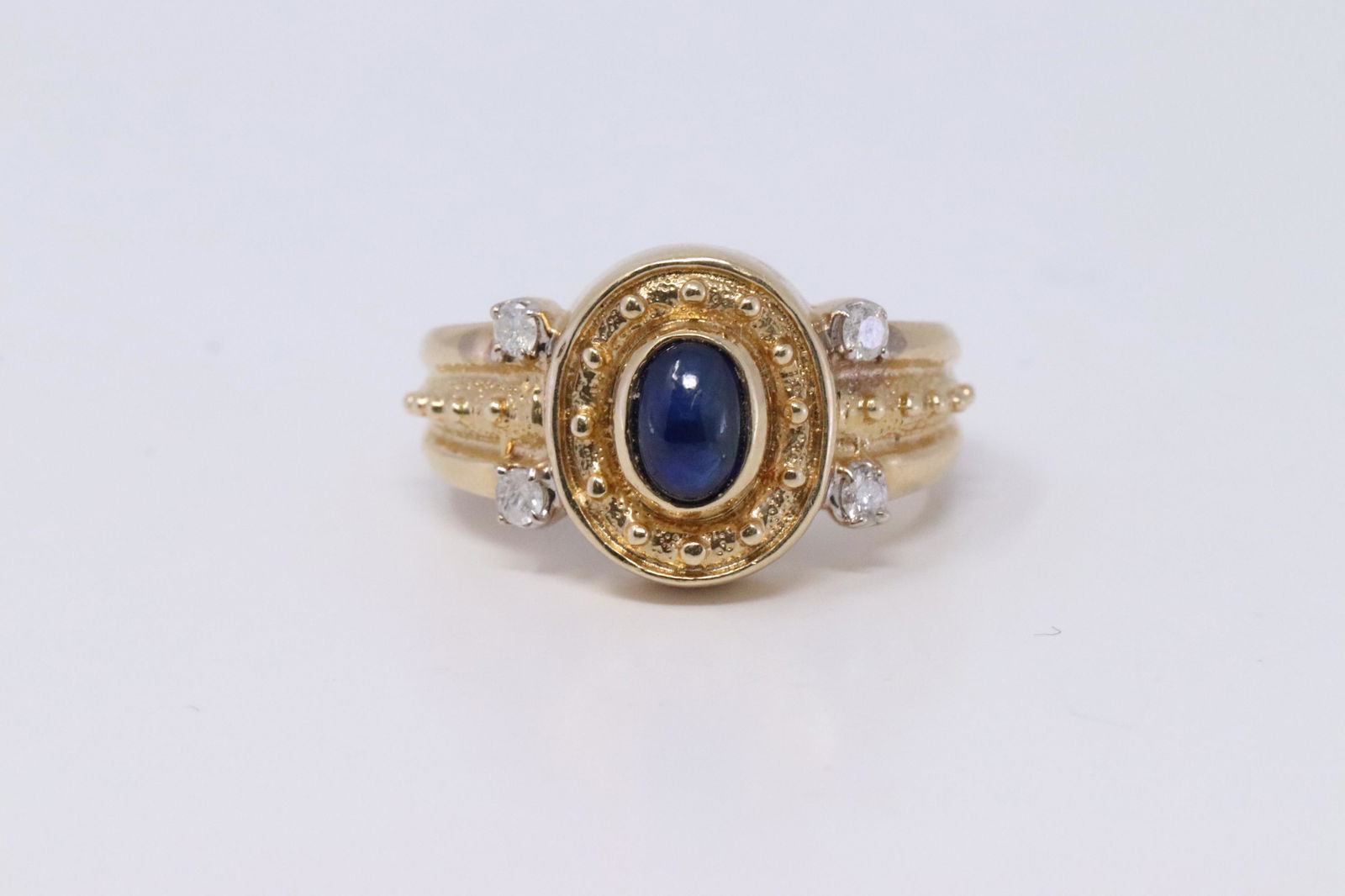 14Kt Vintage Diamond | Cabochon Sapphire Ring: A ladies 14kt vintage Yellow Gold Diamond ring. Ring has a Oval Shape Blue Cabochon Sapphire stone in the center and 4 round diamonds set on the corners. Ring size: 6.00. Sapphire measures: 5.81x4.04m