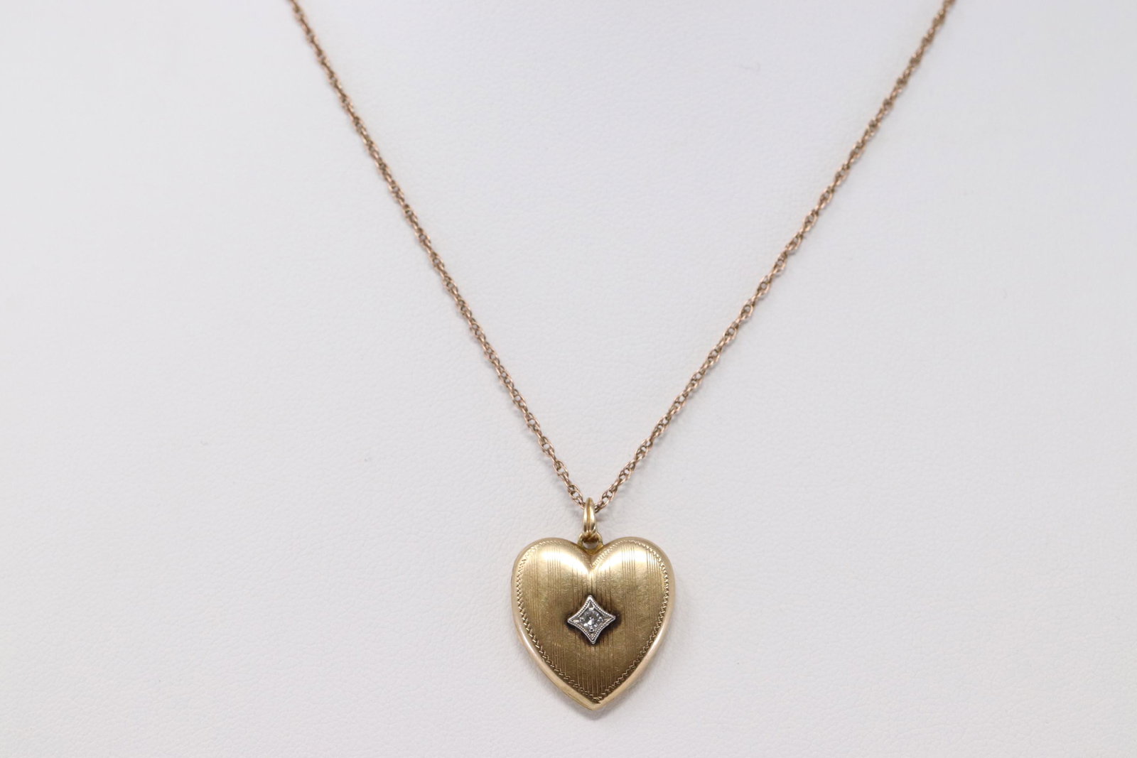 14Kt Yellow Gold Art Deco Heart Locket Necklace: A ladies 14kt Yellow Gold Art Deco Heart Locket. Locket is a Heart Shape with a round diamonds set on the center. Necklace is also 14kt and length: 24in. Total weight: 5.30 grams.
