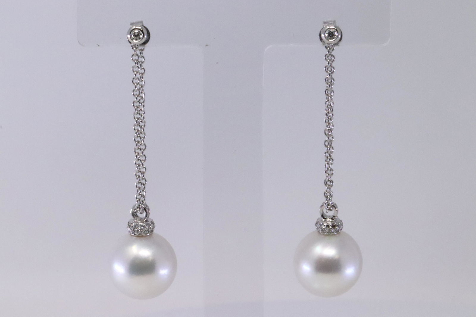 18Kt South Sea Pearl Earrings w/ Diamonds: A Unquie 18kt White Gold Diamond earrings with a Pair of White South Sea Pearl with High Cluster. Pearls measure about 14mm each. Earring design is a double strand with diamonds on top and bottom. The