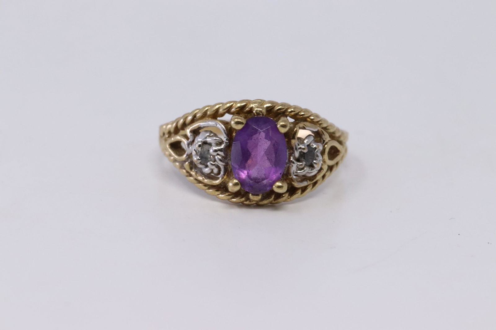 14Kt Vintage Diamond/ Amethyst Ring: A 14kt Yellow Gold Diamond Art Deco ring. Ring has a total of 2 round diamonds on the sides and a Oval shape Amethyst stone in the center. Total weight: 2.20 grams.