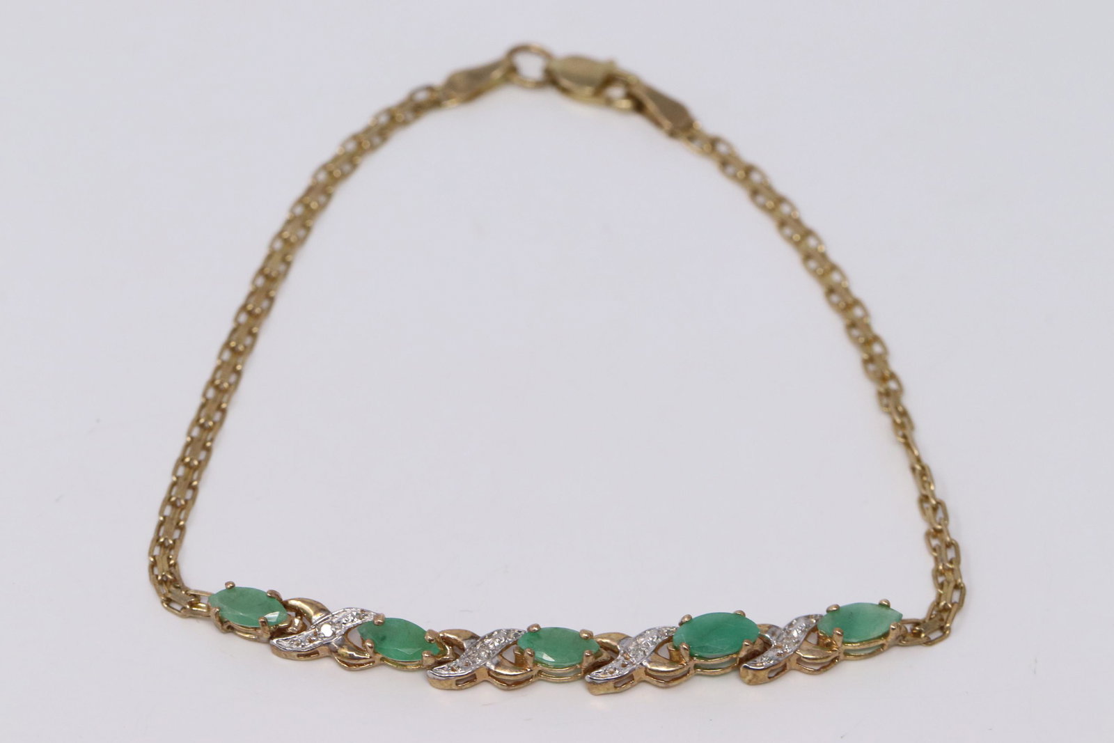 Ladies Diamond/ Emerald Bracelet: A ladies Yellow Gold Diamond bracelet. Bracelet has a total of 5 Marquise shape Emerald stones. Length: 7.00. Total weight 2.80 grams.