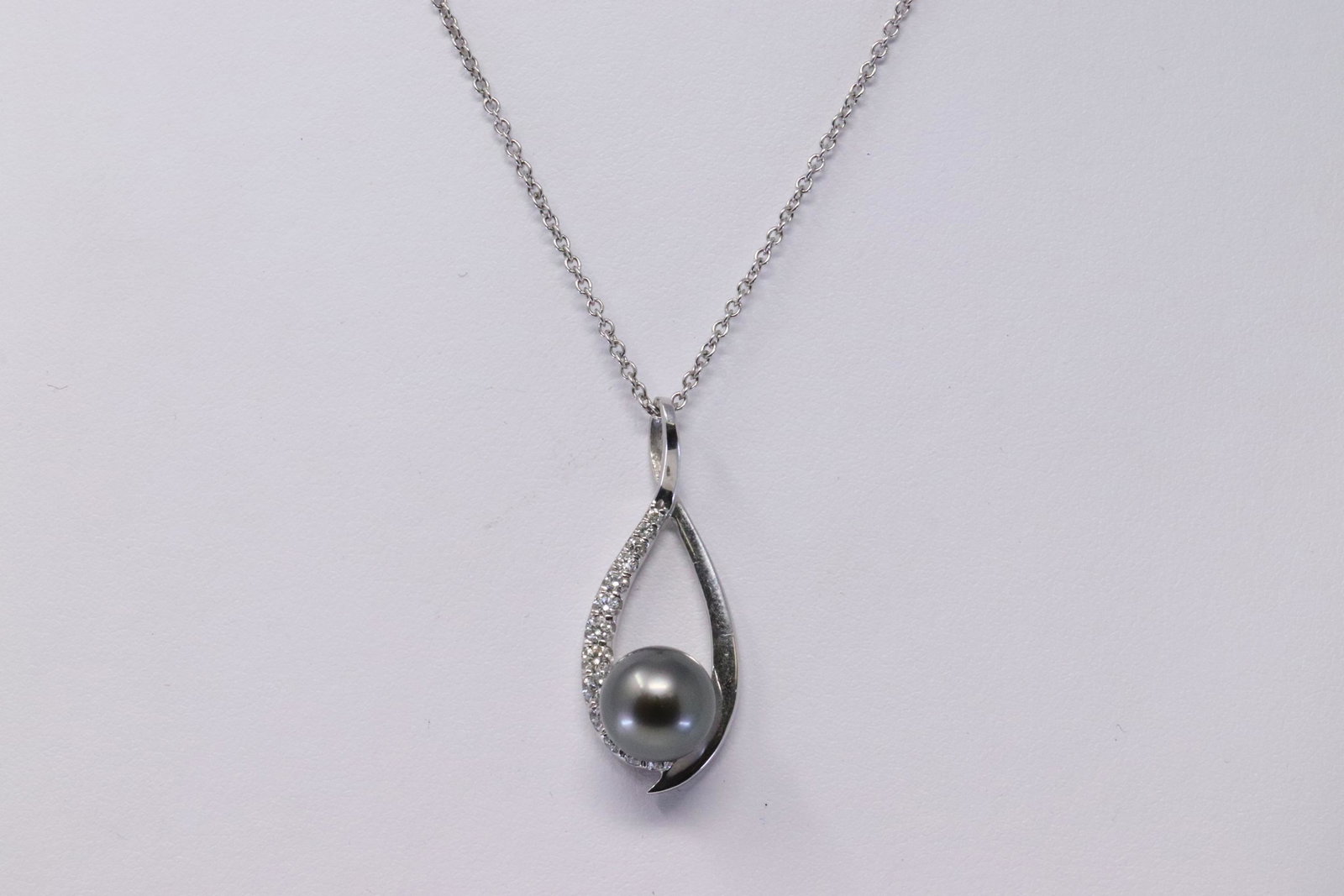 14KT Tahitian Pearl w/ Diamond pendant: A ladies 14KT white gold Tahitian Pearl w/ Diamond pendant. Pendant has a total of 13 round brilliant diamonds. Diamonds weight approx 0.55cttw. Clarity VS1-SI1. Length: 16.00in 14kt necklace. Pearl m