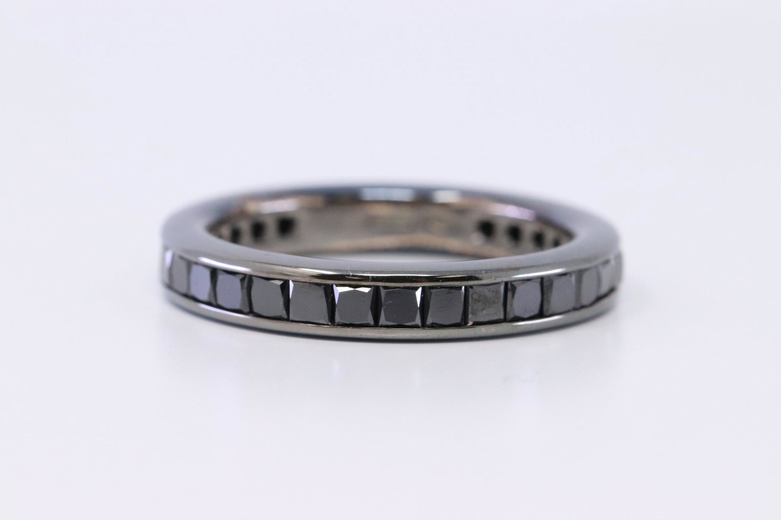 18Kt Men's Black Diamond Eternity Ring: A Men's unqiue 18kt Black Ring with Squared Cut Black diamonds. Diamonds are Black color so is this 18kt ring. Ring has a total of 33 squared black diamonds weighting approx 2.00cttw. Ring size: 9.50.