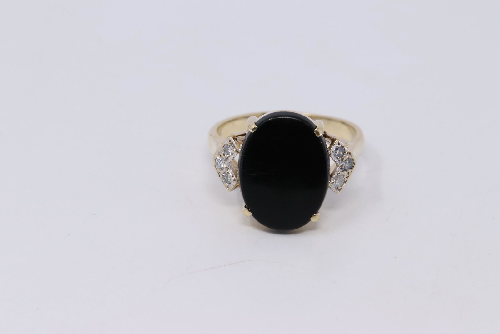 14KT Vintage Diamond/Onyx Ring: A 14Kt Yellow Gold vintage diamond ring. Ring has 6 round diamonds set on the sides and a Oval shape Black onyx stone in the center, Ring size: 8.75. Total weight 5.70 grams.