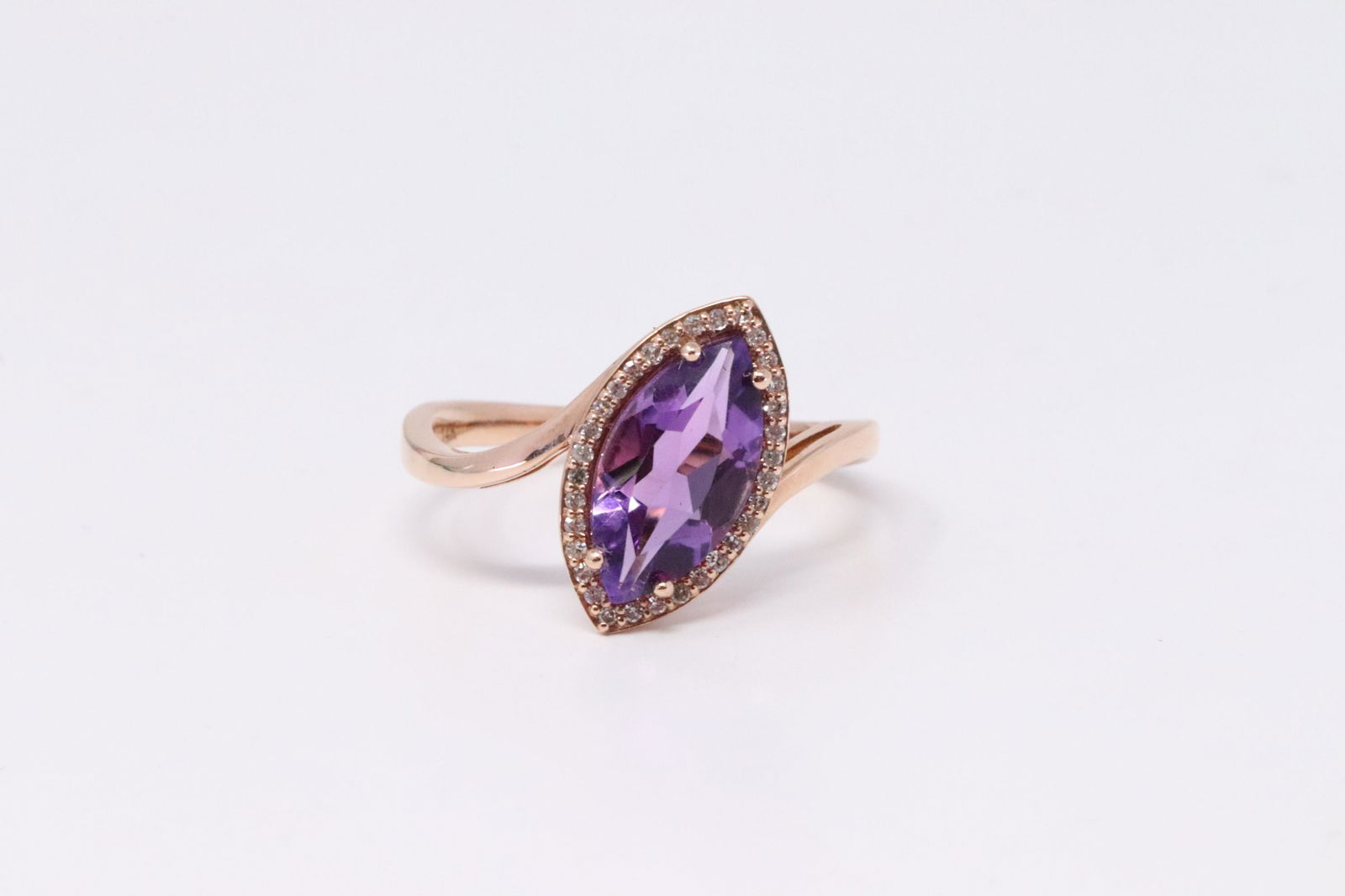 14KT Rose Gold Amethyst Diamond Ring.: Ladies 14KT Yellow Gold Rose Gold Amethyst Diamond Ring. Ring has in the Center Stone Marquise Shape Amethyst Stone & Around Diamods. Diamonds weight approx: 0.10cttw. Ring size: 7.00