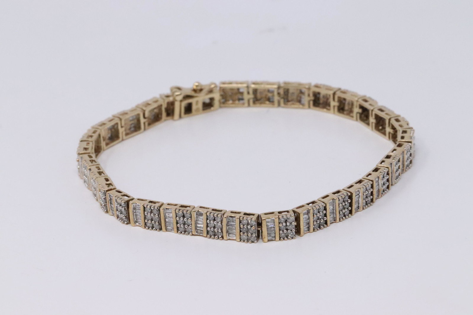 Ladies Diamond Bracelet: A ladies Yellow Gold Diamond Bracelet. The bracelet has a total of 186 round diamonds and around 130 baguette cut diamonds. Total diamond weight is approx 3.50cttw. Length is: 8.00". Total weight: 14.