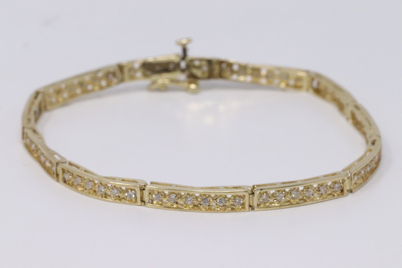 14KT Ladies Diamond Bracelet: A beautiful 14kt Yellow Gold Diamond bracelet. The Bracelet has a total of 66 round brilliant diamonds. The diamonds VS2-SI2 clarity. Bracelet has been fully polished but has minor bent.Length is abou