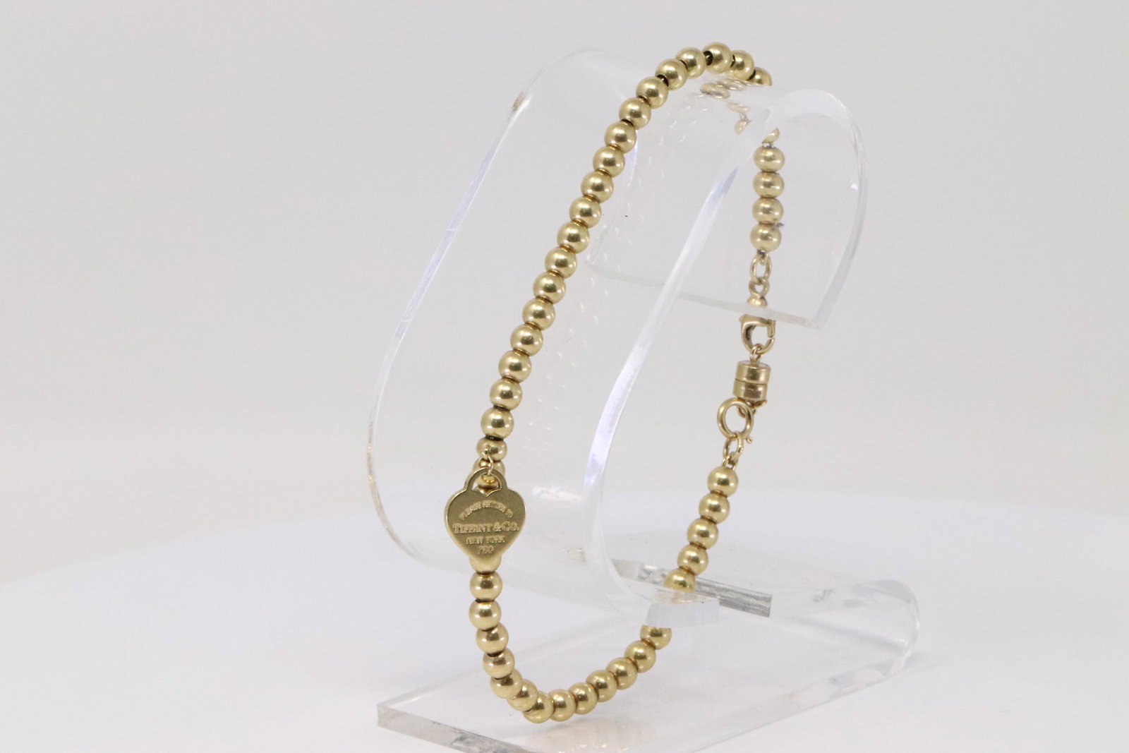 18Kt Heart Tag Return to Tiffany & Co Bead Bracelet: A 18Kt Yellow Gold Tiffany & Co Bead bracelet. Bead measure: 4.00mm. Length of bracelet: 7.50in. Total weight: 9.90 grams.