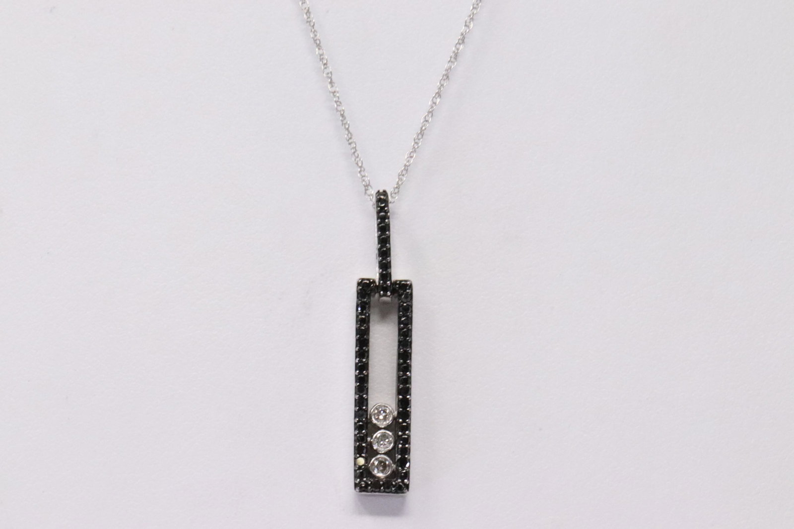 White Gold Diamond Pendant.: White Gold Diamond Pendant. Pendant has Two Diferent Diamonds Black & White With A Necklace. Diamonds weight: 0.25ctw. Necklace length: 18.00" Total weight: 3.08 Grams.