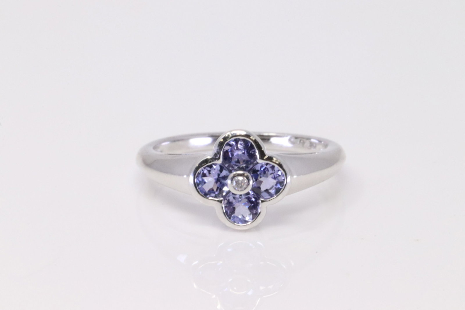 White Gold Tanzanite / Diamond Ring.: Ladies White Gold Tanzanite / Diamond Ring. Ring has one Diamond on the center with 4 Purple Tanzanite. Ring size: 6.75. Total weight: 2.80 Grams.