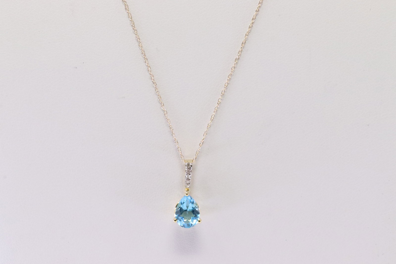 Blue Topaz & Diamond Pendant / Necklace: Ladies 10Kt Yellow Gold Blue Topaz & Diamond Pendant / Necklace. Pendant has Teardrop Blue Topaz Gemstone with 5 Diamonds & A Necklace. Diamonds weight: 0.03 ctw. Necklace length: 18.00"