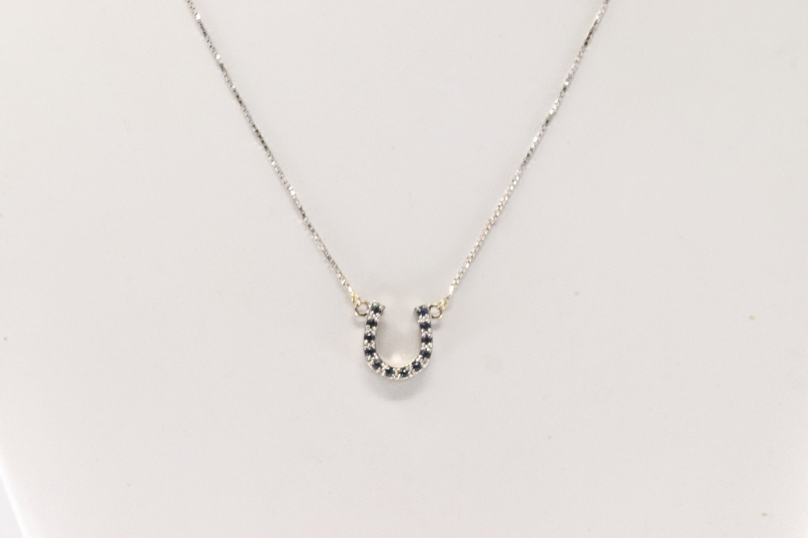 Sapphire Horse Shoe Necklace 14Kt.: 14Kt White Gold Sapphire Horse Shoe Necklace. This necklace has 12 blue round Sapphires around horse shoe. Necklace length: 16.00" Total weight: 3.00 Grams.