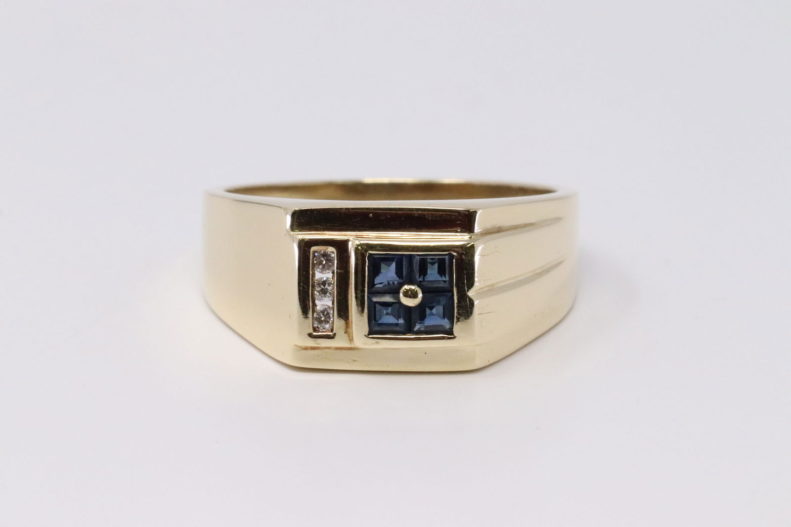 Diamond Sapphires Ring: Yellow Gold Diamond Sapphires Ring. Ring has a total of 3 Diamonds on the Sides and has 4 Sapphires in the Center. Ring size: 11.50. Total weight: 9.00 grams.