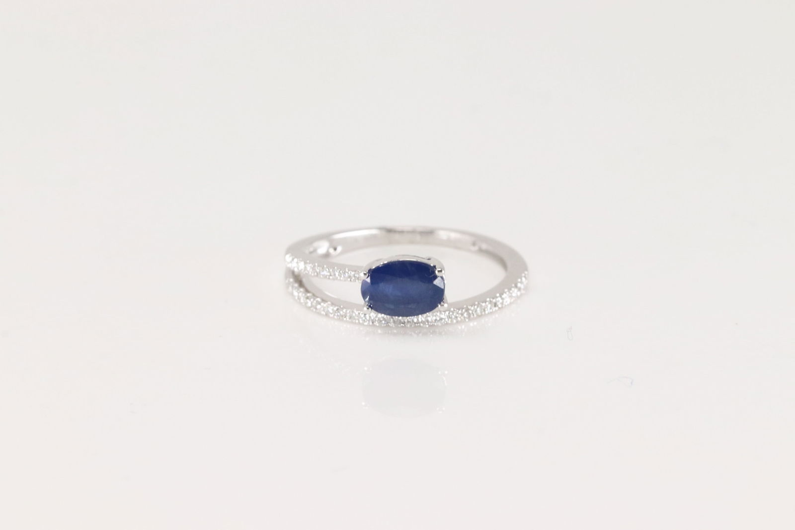 Sapphire & Diamond Ring 14Kt.: Ladies 14Kt White Gold Sapphire & Diamond Ring. This Elegant Ring has Bypass Design with Blue Sapphire Gems and 32 Sparkling Diamonds. Diamonds weight: 0.16ctw. Sapphire weight: 1.07ct. Ring size: