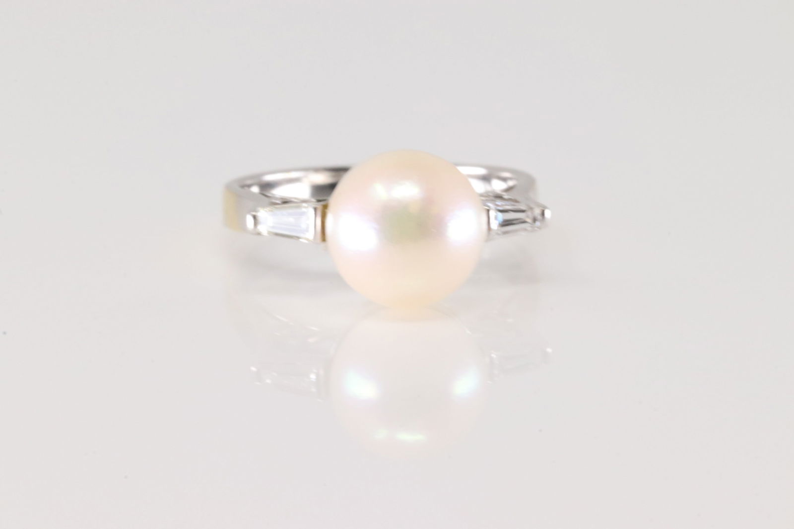 Pearl & Diamond Ring 18Kt.: Ladies 18Kt White Gold Pearl & Diamond Ring. This elegant ring has one pearl on the center with 2 baguette diamonds to the sides. Ring size: 5.00. Total weight: 3.50 Grams.