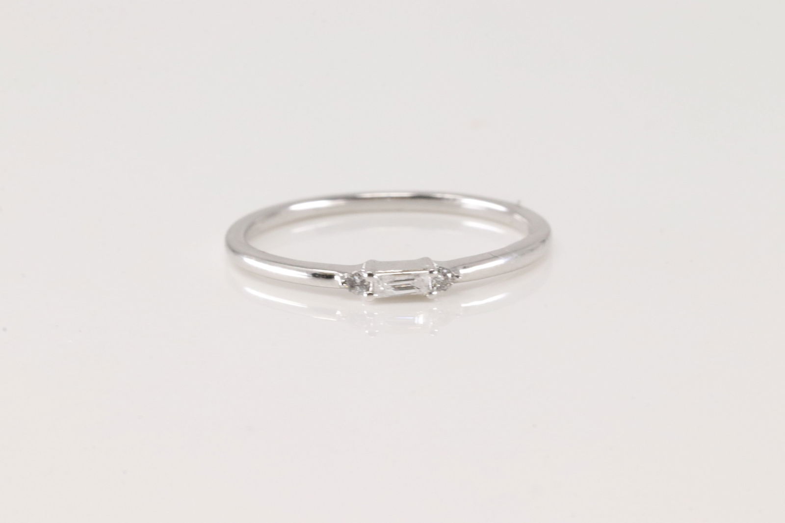 Diamond Ring 14Kt.: Ladies 14Kt White Gold Diamond Ring. This Charming Ring has 2 Roud & 1 Baguette Diamonds. Diamonds wieght: 0.07ctw. Ring size: 6.50.