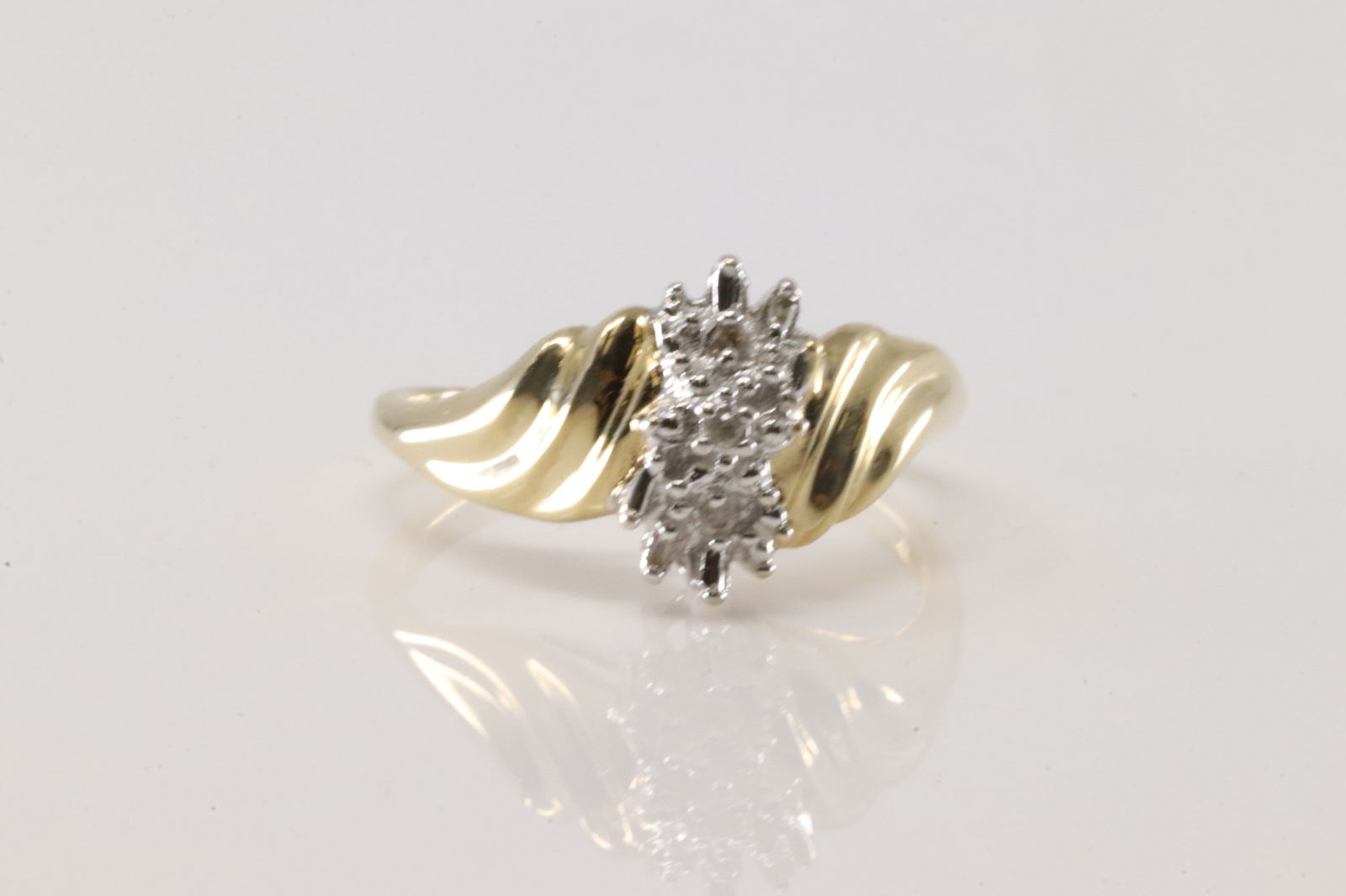 Diamond Ring 10Kt.: Ladies 10Kt Yellow Gold Diamond Ring. Ring has two tone gold with 3 smaller round diamonds & 4 baguette cut. Ring size: 7.25. Total weight: 2.70 Grams.