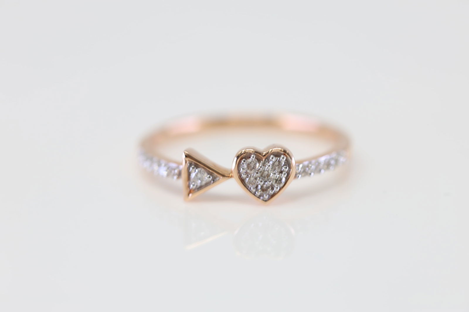 Heart and Triangle Diamond Ring 10Kt.: Ladies 10Kt Rose Gold Heart and Triangle Diamond Ring. This exquisite ring features a delicate balance of elegance and modern design. The band is adorned with sparkling diamonds, leading to two