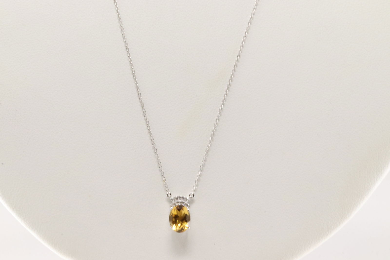 Citrine & Diamond Necklace 10Kt.: Ladies 10Kt White Gold Citrine & Diamond Necklace. Necklace has a Charm with Oval Citrine Ges & Sparkling Diamonds. Diamodns weight: 0.07ctw. Necklace length: 18.00" Adjustable.