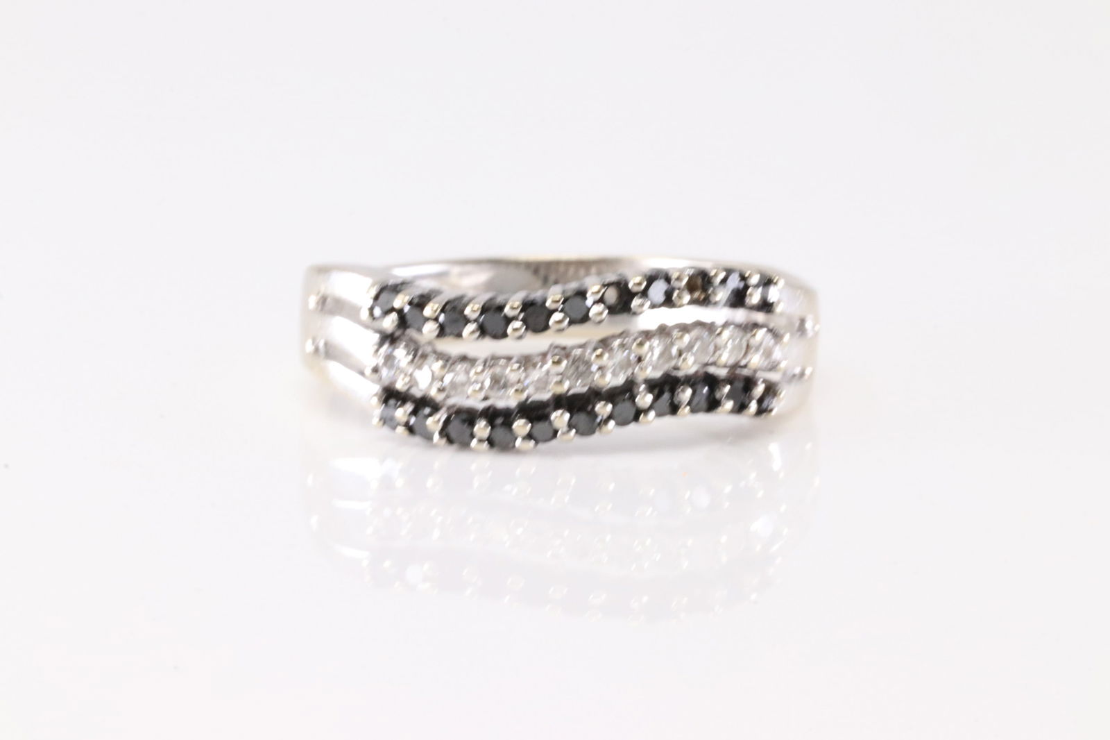 Black & White Diamond Ring 18Kt.: Ladies 18Kt Black & White Diamond Ring. This Elegant Ring has 22 Black Gemstones & 11 Round Sparkling Diamonds. Diamond Weight Approx: 1.00cttw. Ring Size: 8.00. Total Weight: 2.80 Grams.