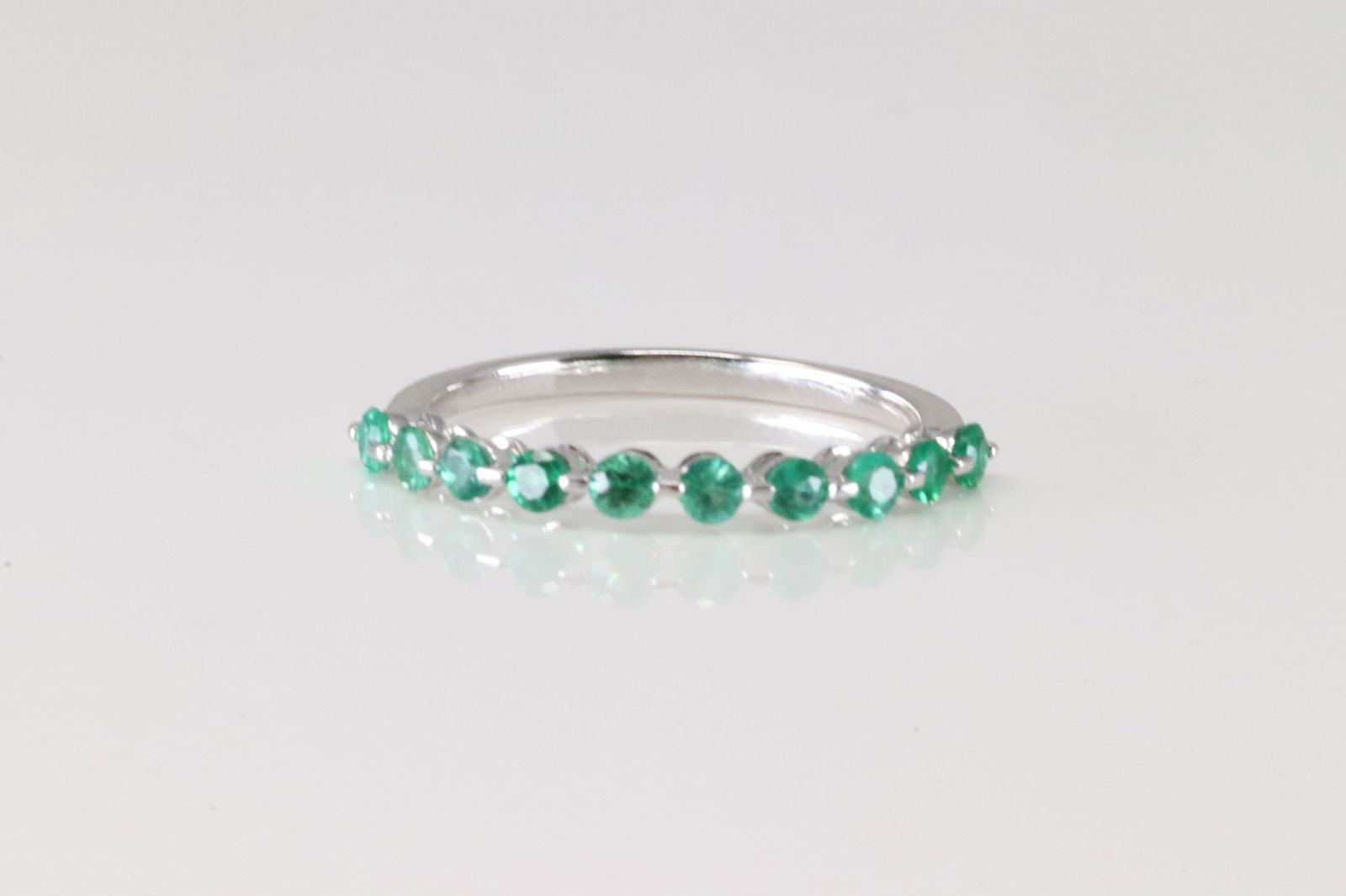 Emerald Ring 10Kt.: Ladies 10Kt White Gold Emerald Ring. This Ring has 10 round Emeralds Gems. 0.65ctw. Ring size: 7.00.