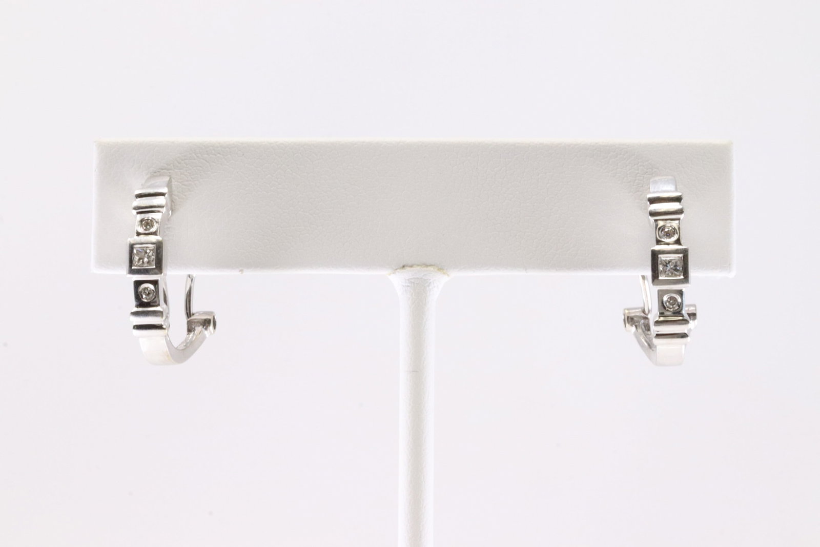 Diamond Huggie Earring 14Kt.: Ladies 14Kt White Gold Diamond Huggie Earring. Earring's has 4 round & 2 Cut Square Diamonds With French Backing Style. Diamonds Approx Weight: 0.20ctw. Total Weight: 4.20 Grams.
