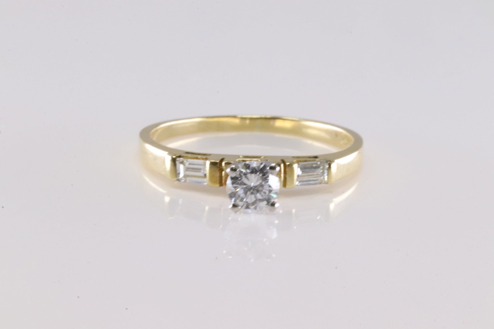 Engagment Diamond Ring 18Kt.: Ladies 18Kt Yellow Gold Engagment Diamond Ring. This Engagment Ring has a Round Sparkling Diamond & 2 Baguette Diamonds. Diamond Approx Weight: 0.40 ctw Ring Size: 8.00. Total Weight: 3.10 Grams.