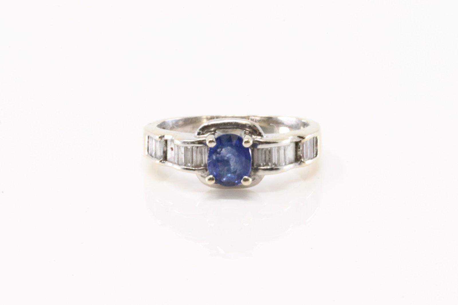 Sapphire & Baguette Diamond Ring 18Kt.: 18Kt White Gold Sapphire & Baguette Diamond Ring. This ring has oval sapphire with approx 20 baguette diamonds. Ring size: 6.50. Total weight: 4.40 Grams.