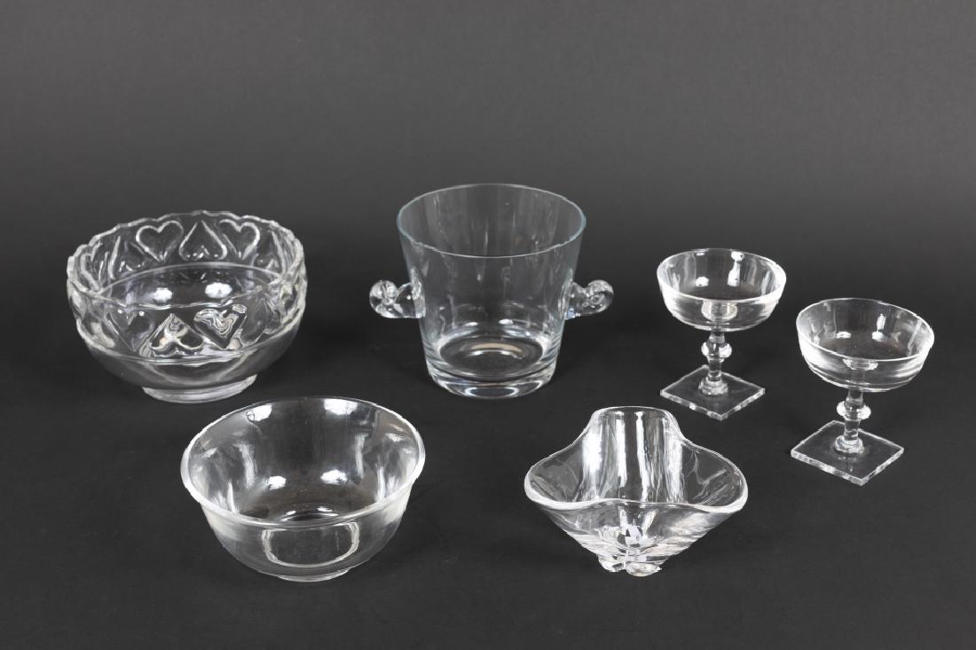 A group of Steuben and Tiffany glassware: Including four stemmed champagne glasses, a wine cooler, a center bowl and two small bowls.(8 in total) Greatest height 6 1/2in. Condition: minor chips to bottom edge of champagne glasses (GMP 655,181