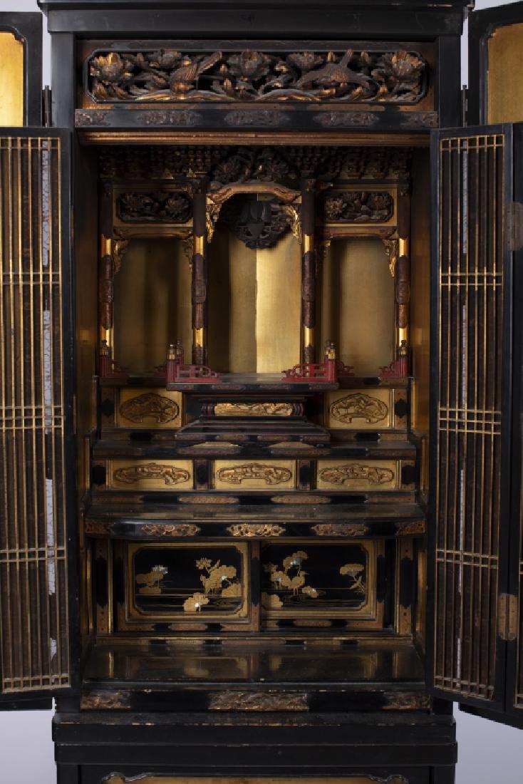 A Japanese parcel gilt lacquer altar, or butsudan: The hinged doors opening to a canopied altar above gilt lotus decorated panels. 57in. H x 21in. W x 17in. L