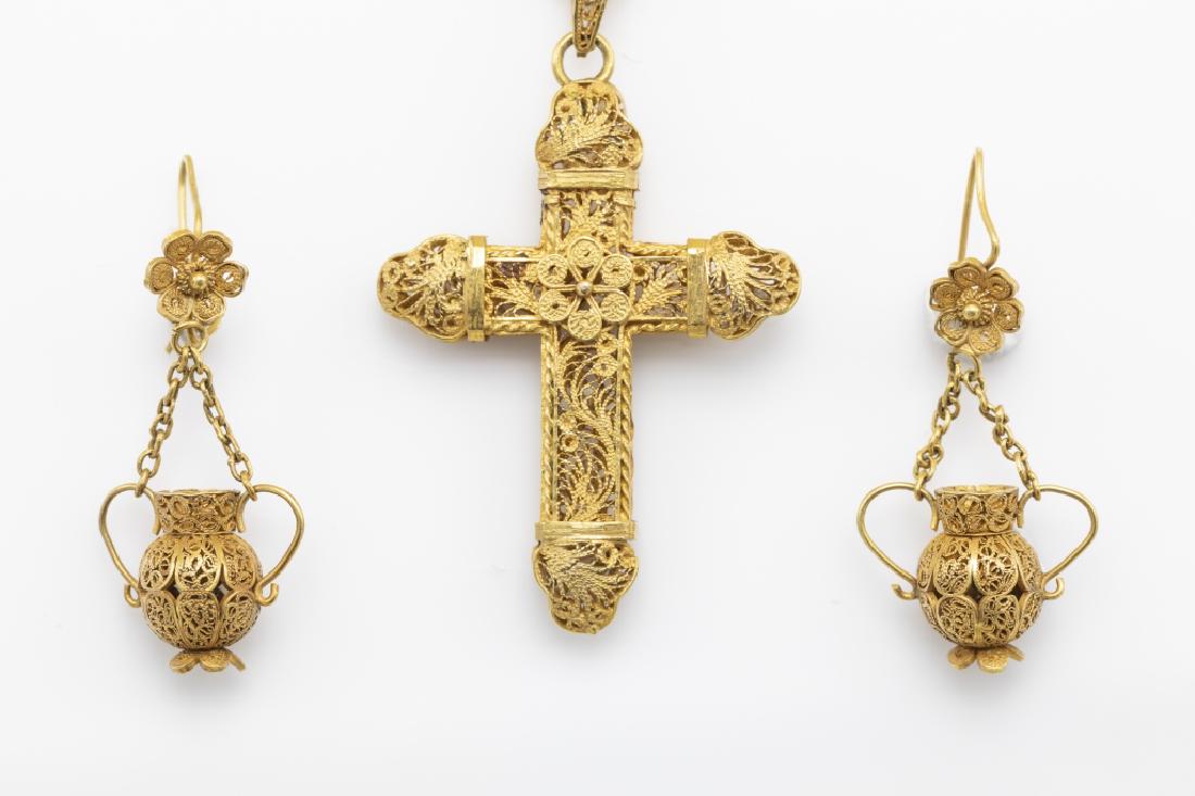A collection of gold cannetille jewelry items: Including a 14k yellow gold cross pendant measuring approximately 47 mm, suspended from a 14k yellow gold 18 inch chain; together with a pair of 14k yellow gold earrings designed as urns, each measuri